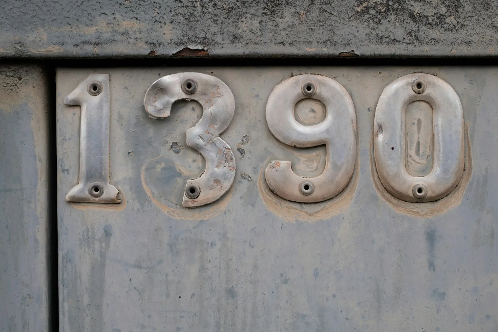 Chiffres en relief sur une plaque métallique usée